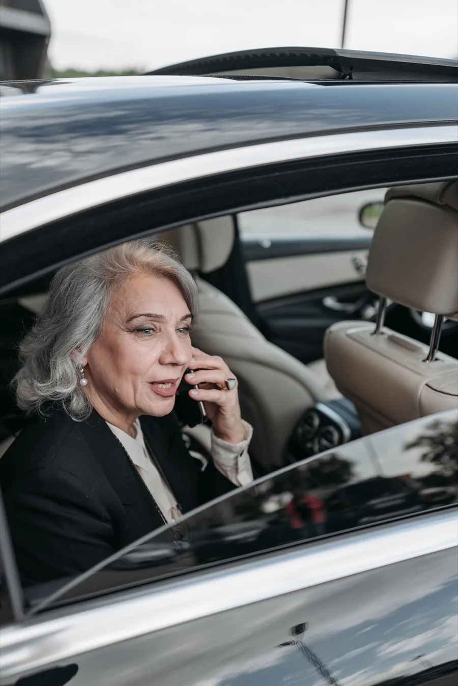 Business passenger working from the rear seat of a chauffeured black Mercedes-Benz sedan on an hourly hire in Morocco